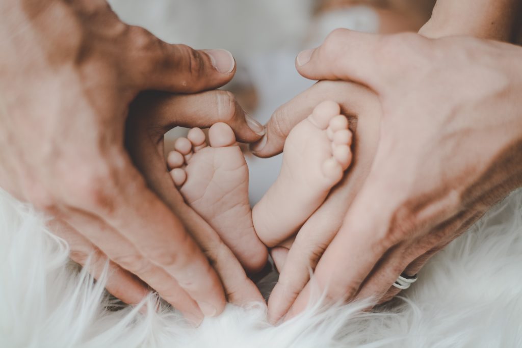 Parents hands and baby feet.