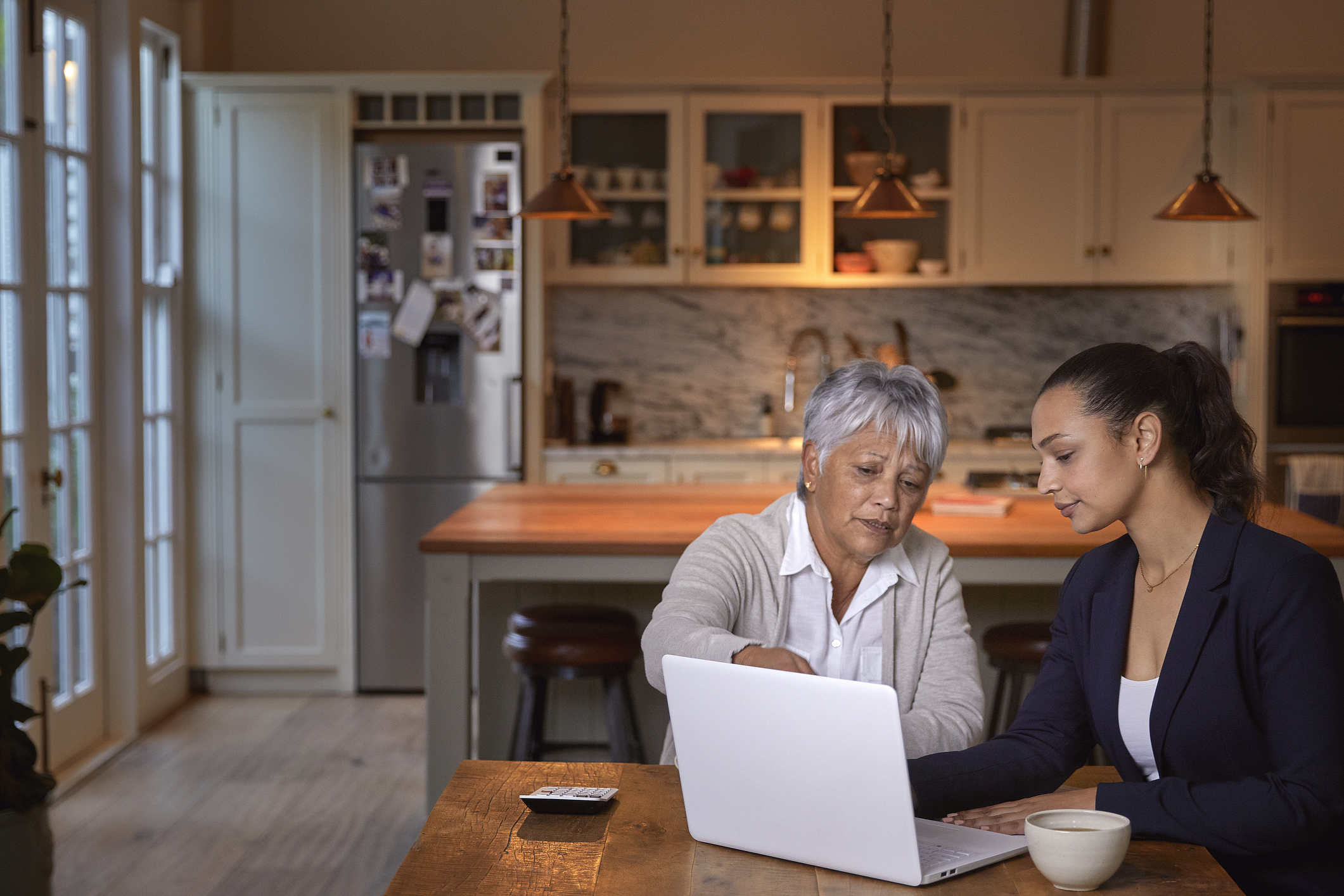 Two adults reviewing healthcare paperwork together at a kitchen table